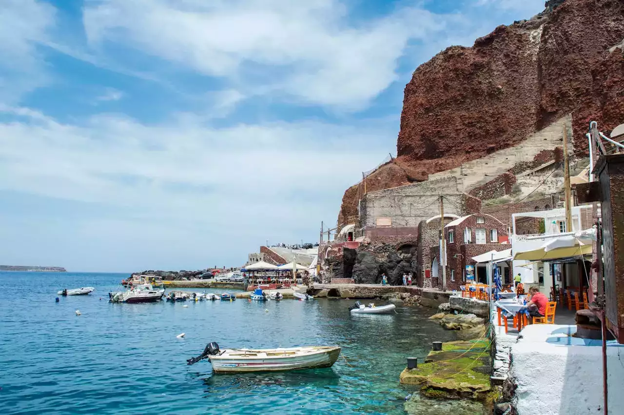 vue panoramique de santorin en Grèce, avec ses criques turquoise, falaises, petits bateaux dans les baies