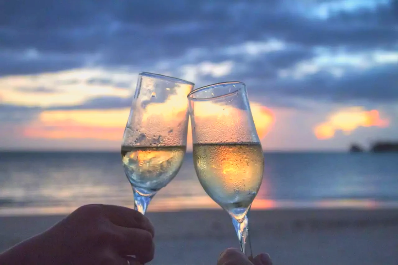 couple avec une coupe de champagne sur la plage
